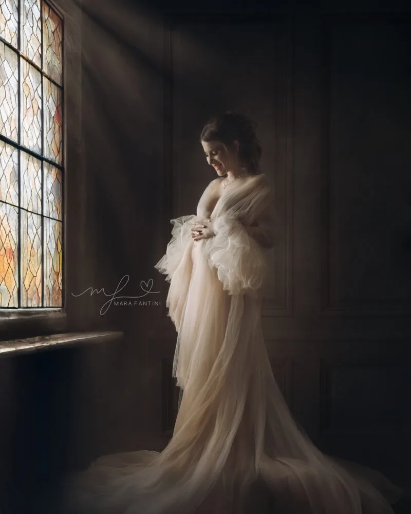 Ritratto gravidanza fine art in stile Caravaggio Ritratto fine art maternità a Roma in stile pittorico rinascimentale, donna con abito in tulle verde e sfondo ocra, fotografia d'autore di Mara Fantini.