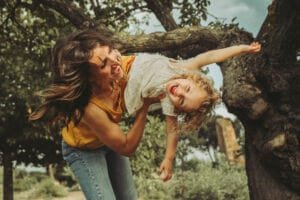 Mamma gioca con la bambina tra vento e risate sotto un albero, Parco degli Acquedotti Roma